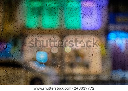 defocused bokeh lights at Phuket old town view past glass and drop water