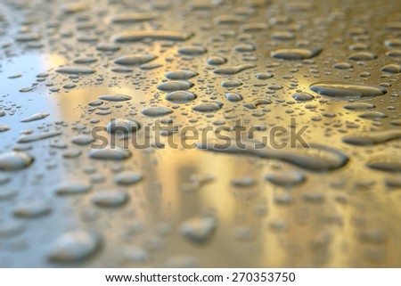 drops of water on hood of a car bronze color