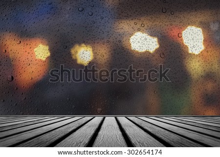 old wooden floor platform with rainy drops water on glass
