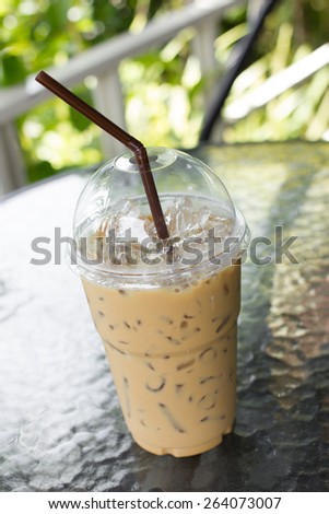 take-home cup of ice coffee on table.