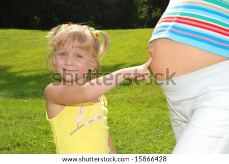 Cute Little Girl Is Pointing At Pregnant Mommy'S Belly Stock Photo ...