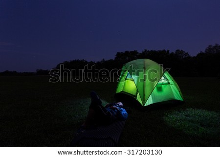 JUGRA, MALAYSIA - AUGUST 1 : Camper lay outside his tent during a clear night on 1 August 2014.