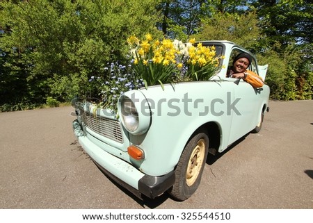 LISSE, NETHERLANDS - MAY 9 2011: Tourist pose in the car decorated with flowers in Keukenhof Garden.