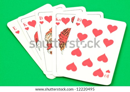 Play cards shows a winning hand, royal flush on green textured background