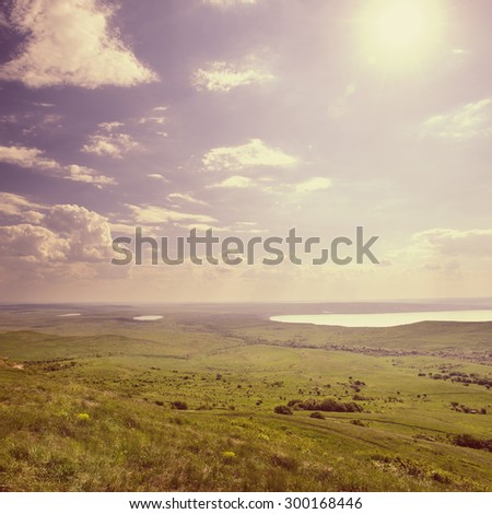 Photo of beautiful landscape with grassy and land lake under sunny skies in vintage style