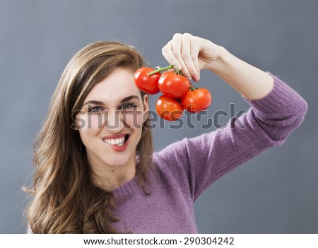 gorgeous young woman biting lips for resisting in eating grape of tomatoes for veggie health and good appetite