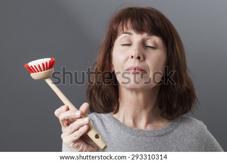 zen mature woman with dish brush in hand as relaxation and soothing cleaning exercise