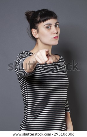 severe young brunette woman staring at someone with index finger forward accusing and patronizing someone with firmness