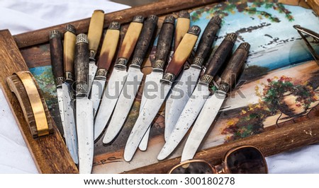 display of old knives on retro 30s or 40s wooden tray sold at flea market for antique collection or collection fans
