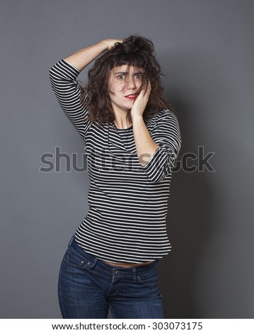 madness and fear concept - 20s woman with brown hair looking mad and scared,studio shot
