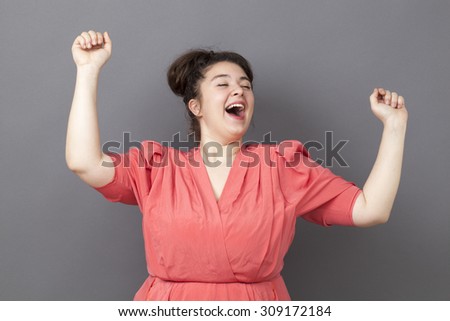 success concept - ecstatic young fat girl dancing wearing a vintage dress expressing her achievement and energy