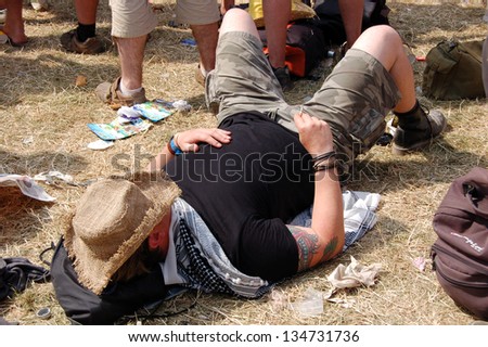 GLASTONBURY,UK - JUNE 27: A festival goer has a rest as a crowd of music fans gather by the Pyramid Stage at  Glastonbury Festival on 27th June, 2010 at Pilton Farm, Somerset.