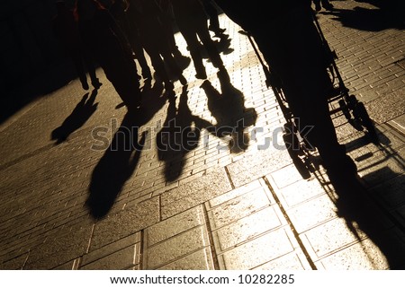 Shadows of people walking on the city street