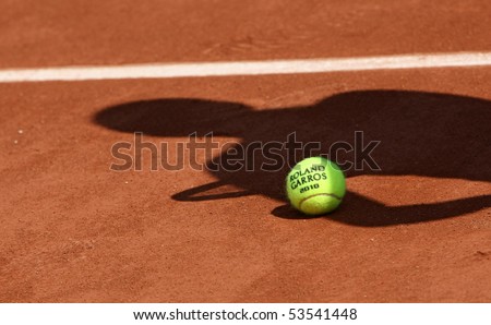 PARIS - MAY 20: Official ball of the French Open Grand Slam tennis tournament with the shadow of a tennis player on the clay clourt of Roland Garros on May 20, 2010 in Paris, France.