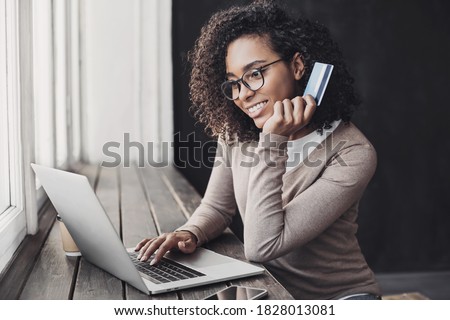 Young woman holding credit card and using laptop making payment online. Businesswoman or entrepreneur working at home. Online shopping, e-commerce, banking, internet store, spending money concept