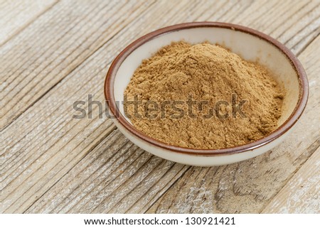 raw organic dried camu camu fruit powder (Myciara Dubia) in a small ceramic bowl - rainforest superfruit from Peru rich in vitamin C