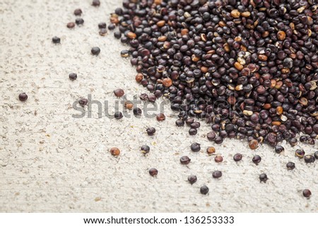 black quinoa grain grown in Bolivia on rough white painted barn wood background