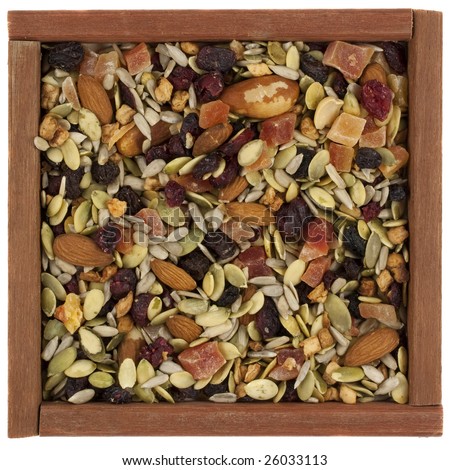 trail mix with pumpkin, sunflowers seeds, almonds, dried papaya,  cranberries, raisins, apples, Brazilian nuts in a rustic wooden box or frame  isolated on white