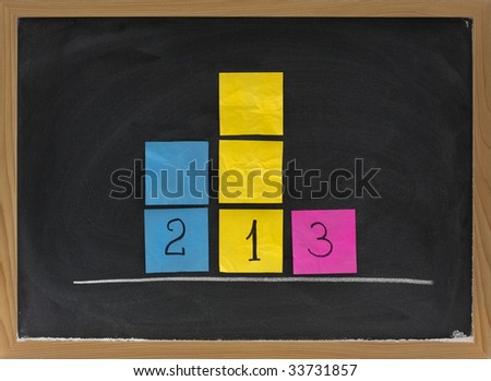 concept of three level podium to honor medalists in sporting events presented with sticky notes on blackboard