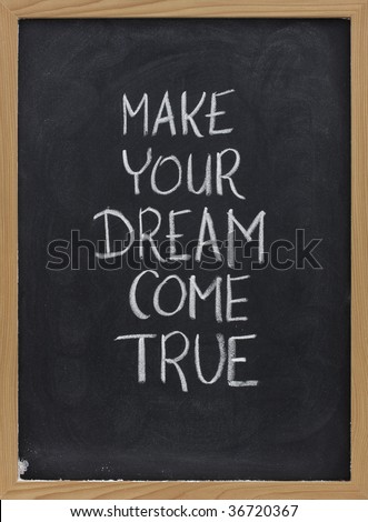 make your dream come true - motivational slogan handwritten with white chalk on blackboard