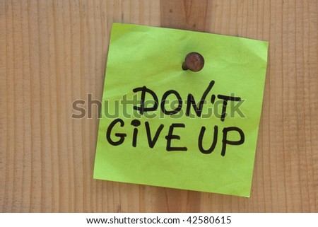do not give up  - motivational reminder on post note nailed to wooden plank or wall