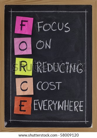 FORCE acronym (focus on reducing cost everywhere) - white chalk handwriting and color sticky notes on blackboard