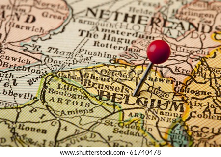Belgium and Brussels (European Union Center) on vintage 1920s map with a red pushpin, selective focus