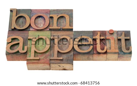 bon appetit - phrase  in vintage wooden letterpress printing blocks, stained by color inks, isolated on white