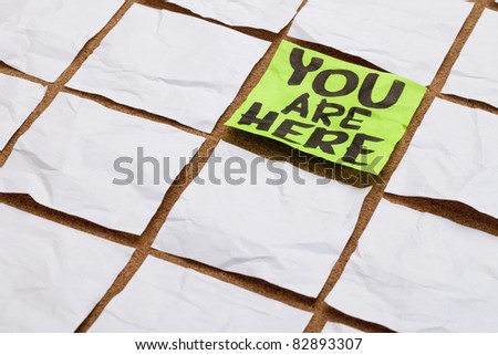 you are here concept - handwriting on a green sticky note surrounded by blank white ones