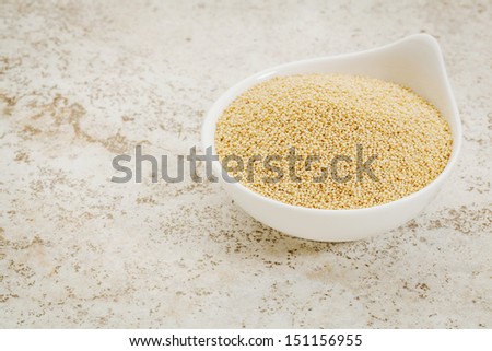 small ceramic bowl of  amaranth grain against a ceramic tile background with a copy space