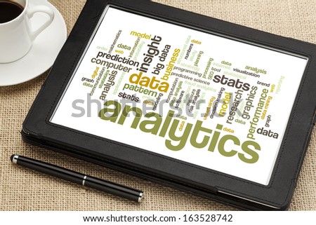 cloud of words or tags related to analytics and data analysis on a  digital tablet with a cup of tea