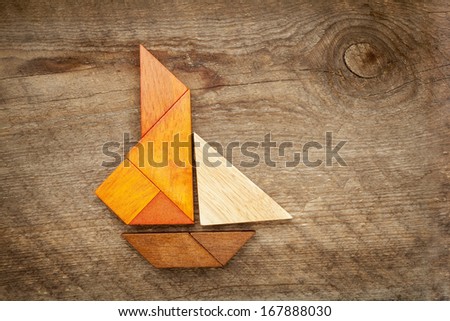 abstract picture of a sailing yacht built from seven tangram wooden pieces over a rustic  barn wood, artwork created by the photographer