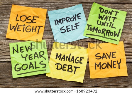 New Year goals or resolutions - handwriting on sticky notes against grained wood