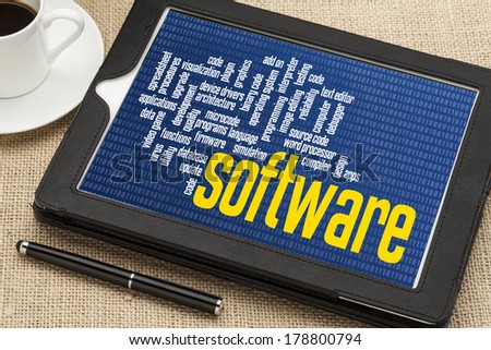 computer software word cloud on zero one binary background - digital tablet with a cup of coffee