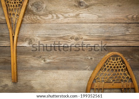 vintage Huron snowshoes against grained wood planks with a copy space