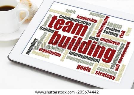 team building word cloud on a digital tablet with a cup of coffee