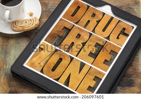 drug free zone word abstract in vintage letterpress wood type on a digital tablet with a cup of coffee