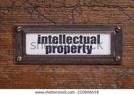 intellectual property  - file cabinet label, bronze holder against grunge and scratched wood