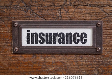 insurance - file cabinet label, bronze holder against grunge and scratched wood