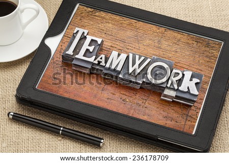 teamwork  word in vintage metal type printing blocks on a digital tablet with a cup of coffee
