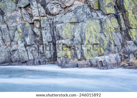 frozen river and canyon wall covered by lichen - Cache la Poudre River at Gateway near Fort Collins, Colorado