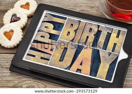 happy birthday typography - isolated text abstract in letterpress wood type printing blocks on a digital tablet with tea and heart cookies