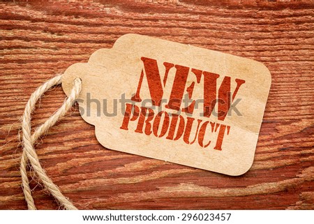 new product sign - a paper price tag against rustic red painted barn wood - innovation and marketing concept