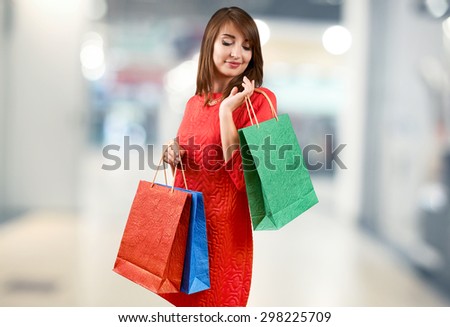 Smiling woman with a gift bag on a light background
