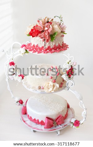 Wedding cake with red flowers on a light background.