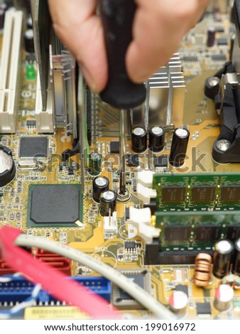 technician is repairing computer using screwdriver