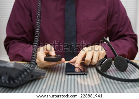 businessman is using two mobile phones and land line telephone at the same time