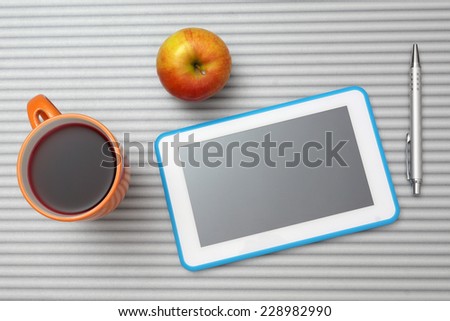 top view of desk with tablet pc, cup of tea , apple