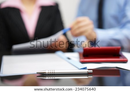two people discussing about report on business meeting with focus on pen