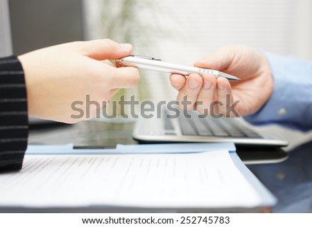 Businessman give client pen to sign the contract in office
